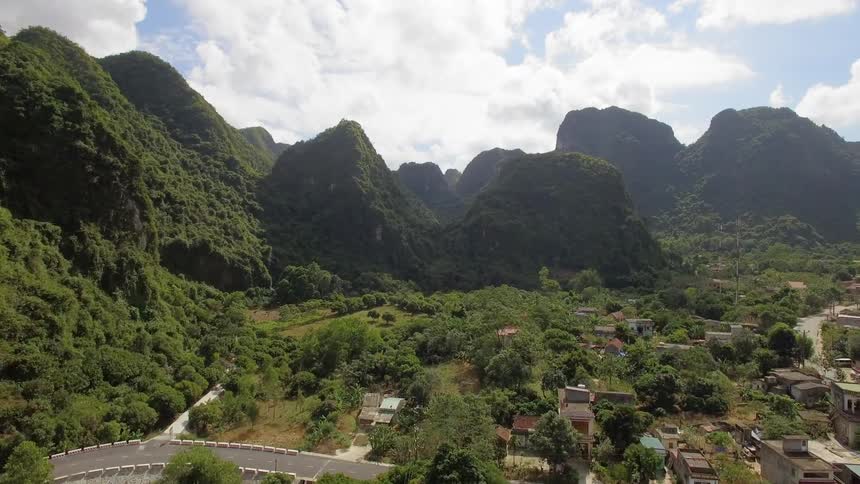 A village with a road with cliffs in the background