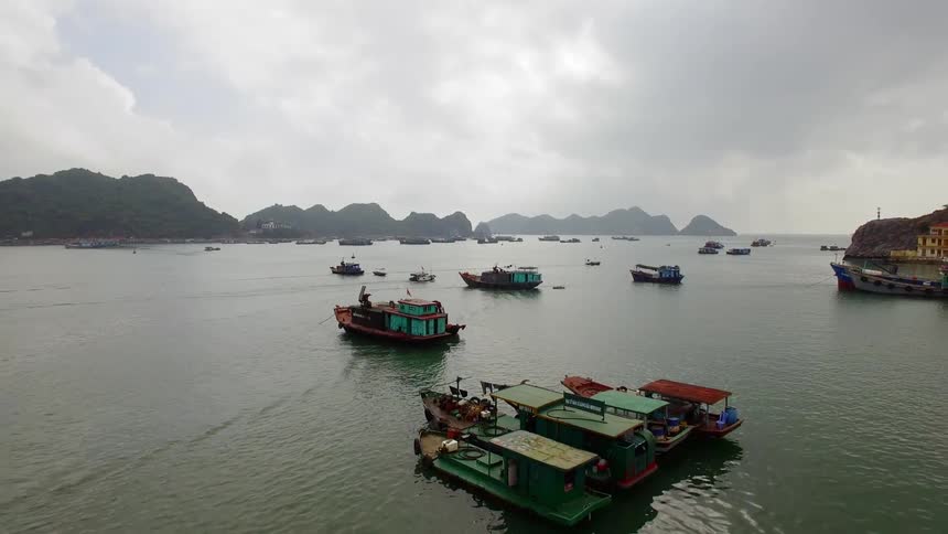 A river with boats with mountains and the sky in the background