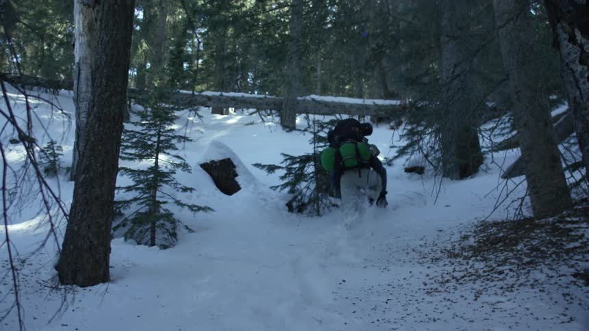 A person hikes up a snowy hill