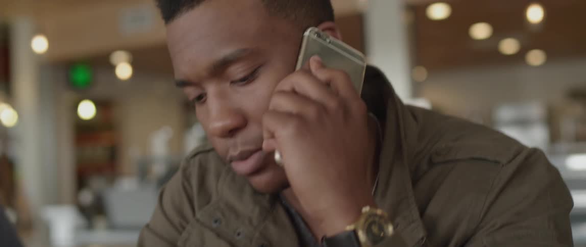 A man is talking on his phone inside a restaurant