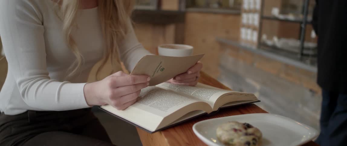 A woman reads a book in a restaurant
