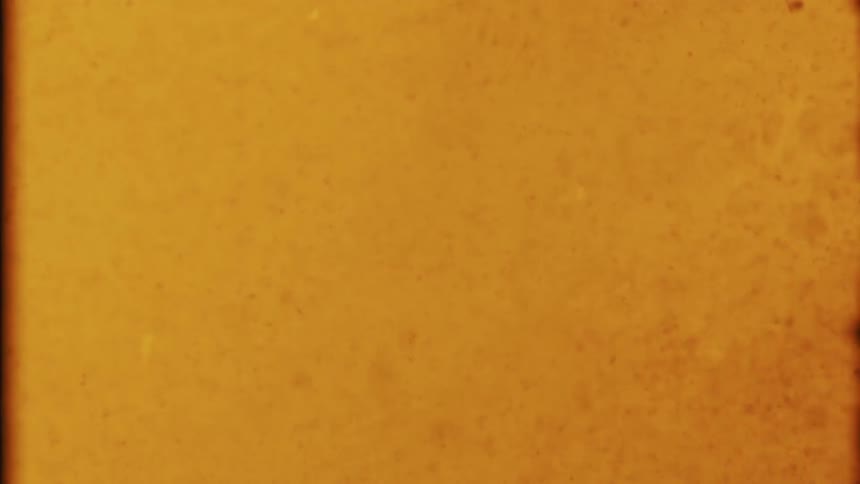 Flowing glowing orange liquid with brown specks falling