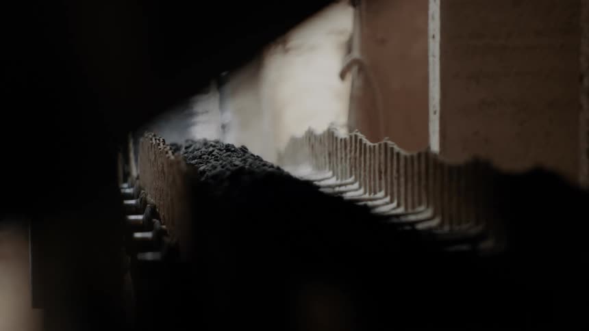 Coal moving along a conveyor belt in a factory