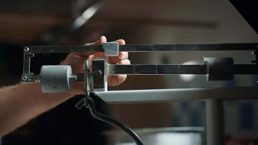 Man slides a weight on a medical scale