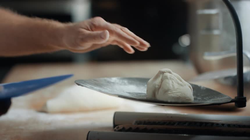 A man weighs dough on a scale