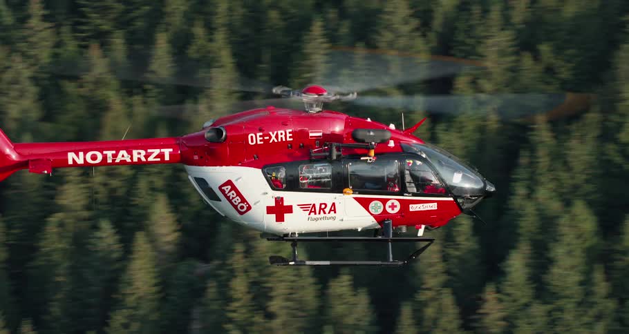 Close up of rescue helicopter flying over the forest in the mountains