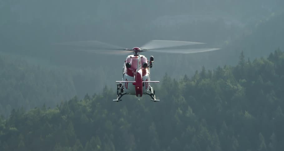 Search and rescue helicopter flies over the forest in the air