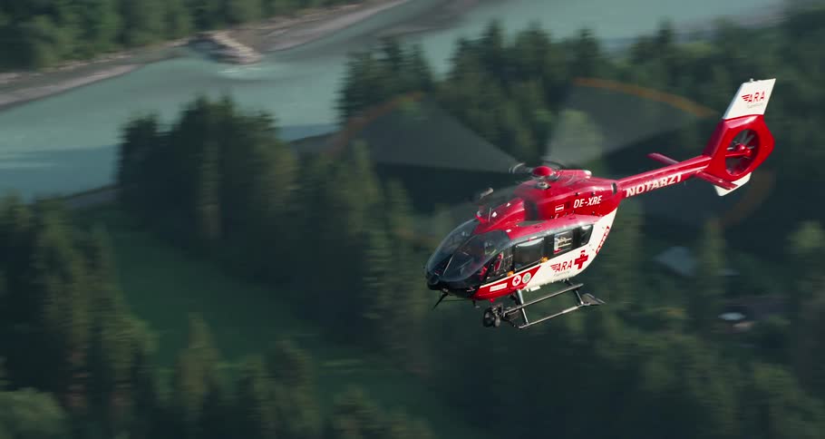 A medical helicopter flies over the land and a river