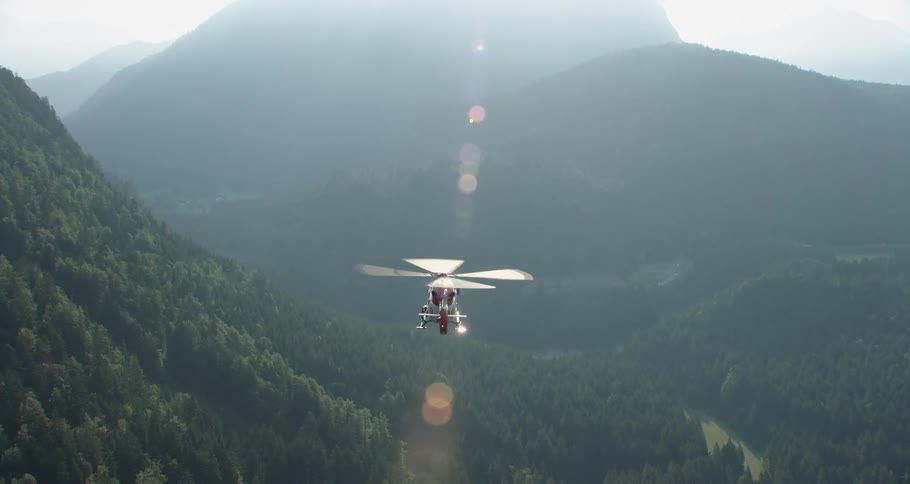 Helicopter flying through mountains and forest area