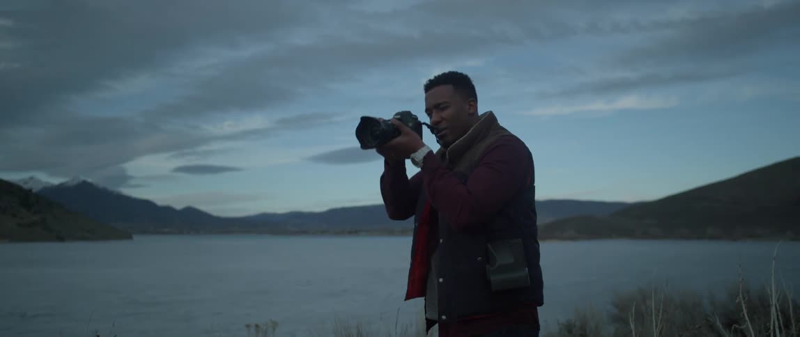 A man taking pictures next to a lake