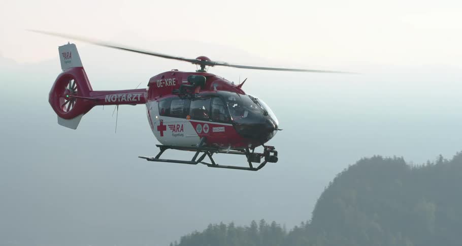 Rescue helicopter hovering over the mountains on a foggy day