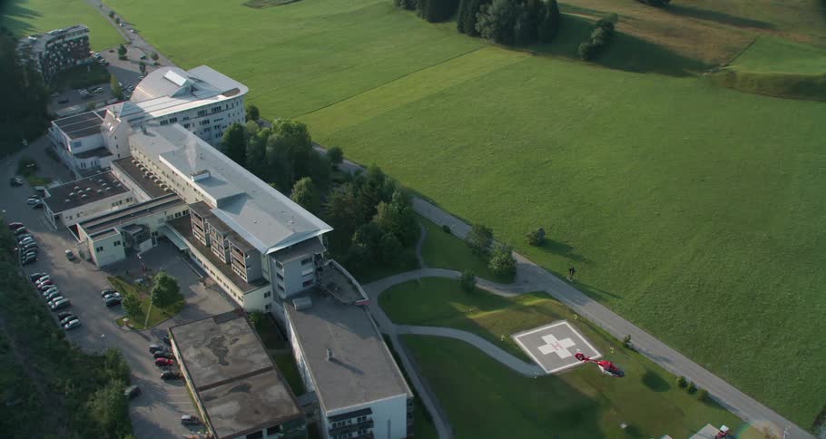 Hospital with a helipad where a helicopter is flying from