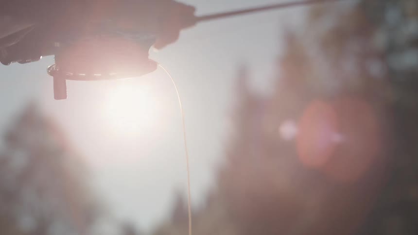 Man casts a fishing line in the river on a sunny day
