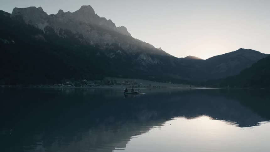 Two people on a small boat in the middle of a lake
