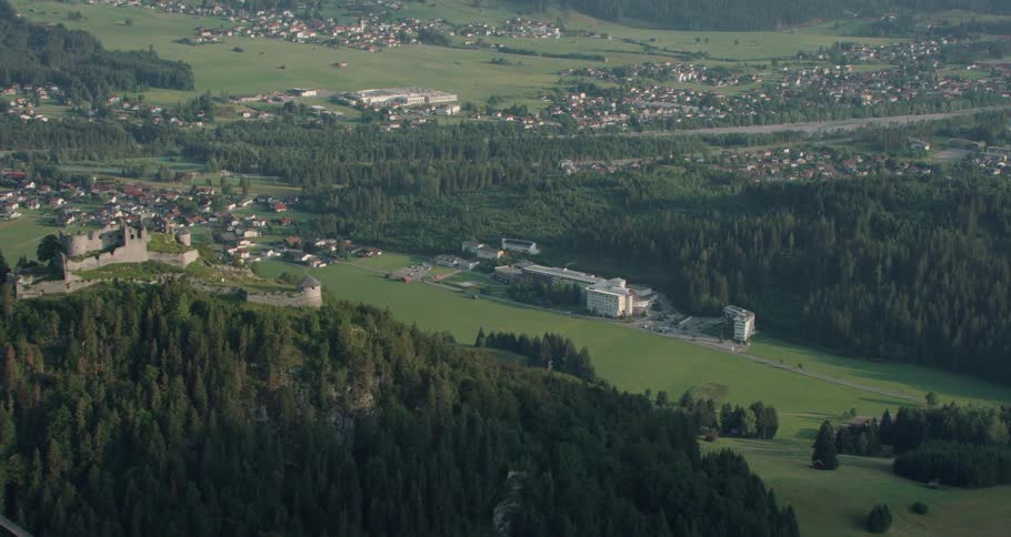 Buildings sit next to a green forest