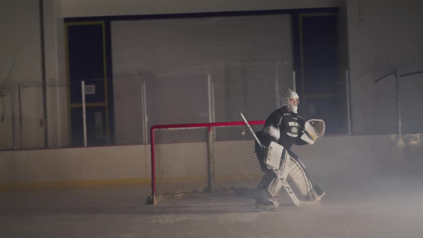 Goaltender stands in the teams goal to try to stop the other team from scoring during the game in the ice hockey rink