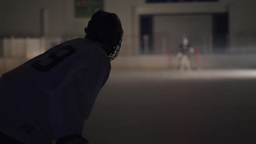 Goalie stands in net as he waits for the other player to shoot the puck