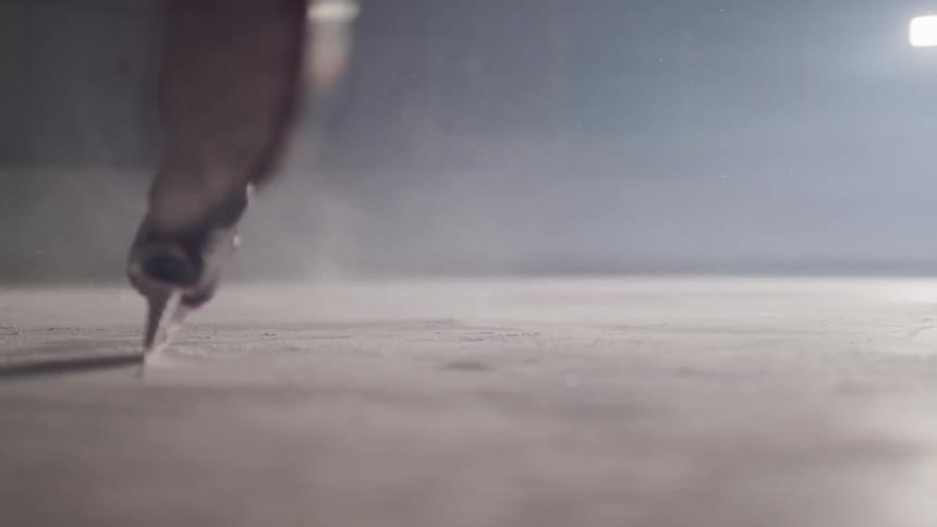 A person slaps a hockey puck on an ice rink