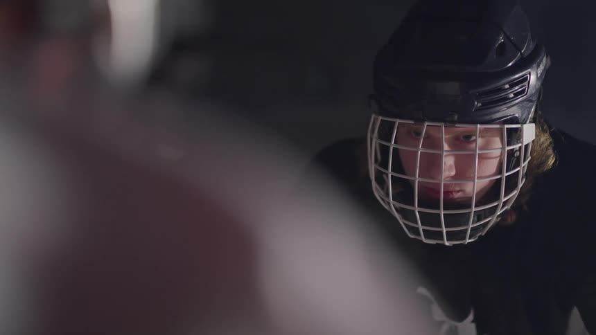 A hockey player raising their head to face another player standing across from them