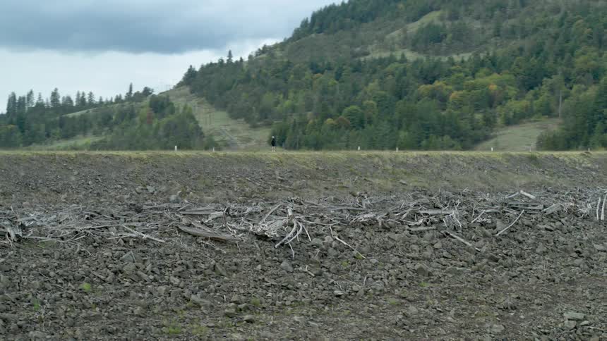 A man stands on a hill and looks out across the land