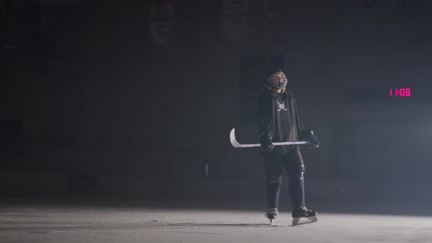 Hockey player holds a hockey stick while skating across the ice