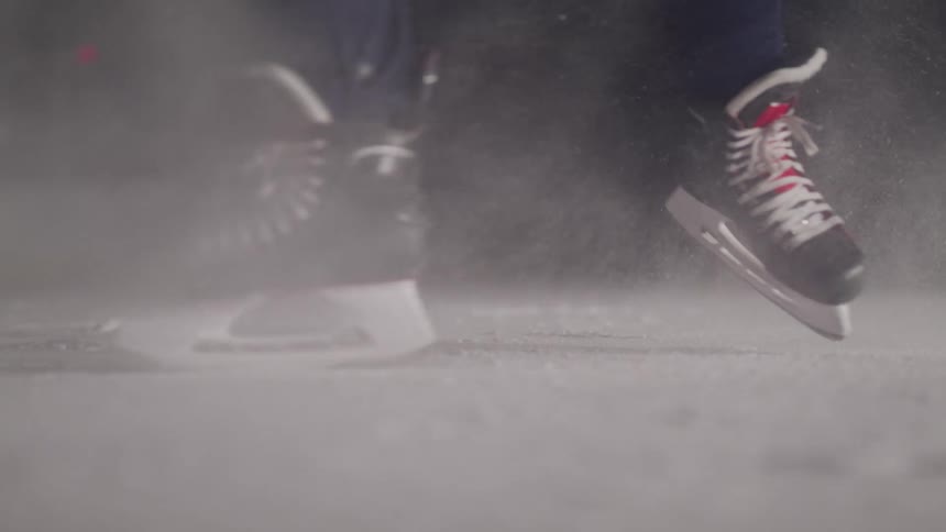 Ice skater stops temporarily kicking up a spray of ice