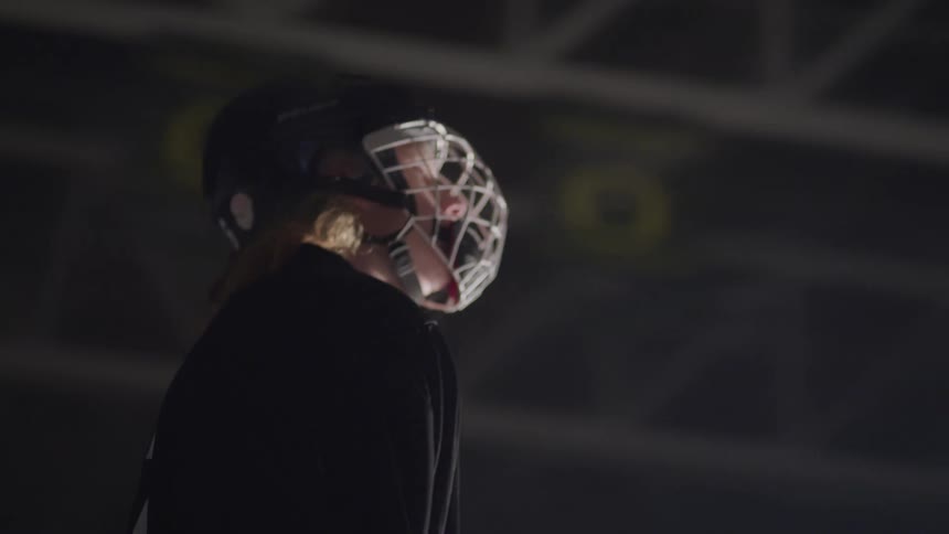 A hockey player stands still looking up
