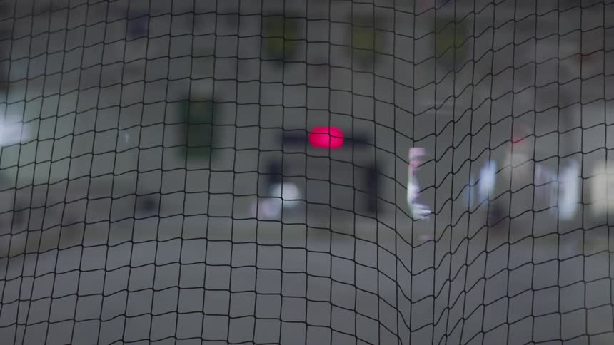 The inside of a gymnasium is blurred when viewed through a net