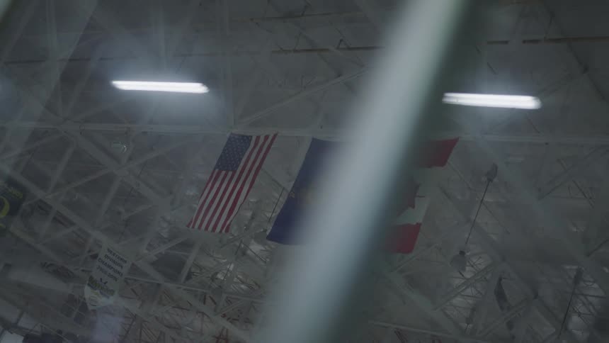 Flags hanging from the rafters in an ice rink