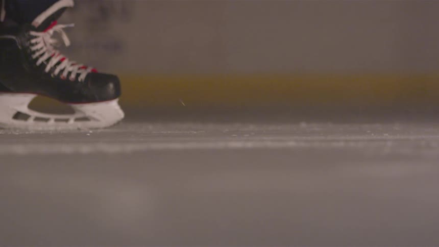 A hockey puck being hit by a stick in a rink