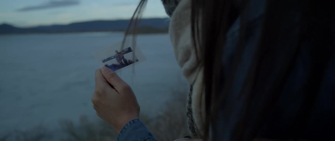 Woman holds a photograph outside