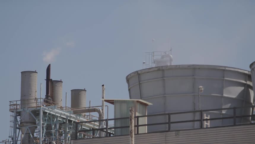 A factory with smoke coming out of the chimneys