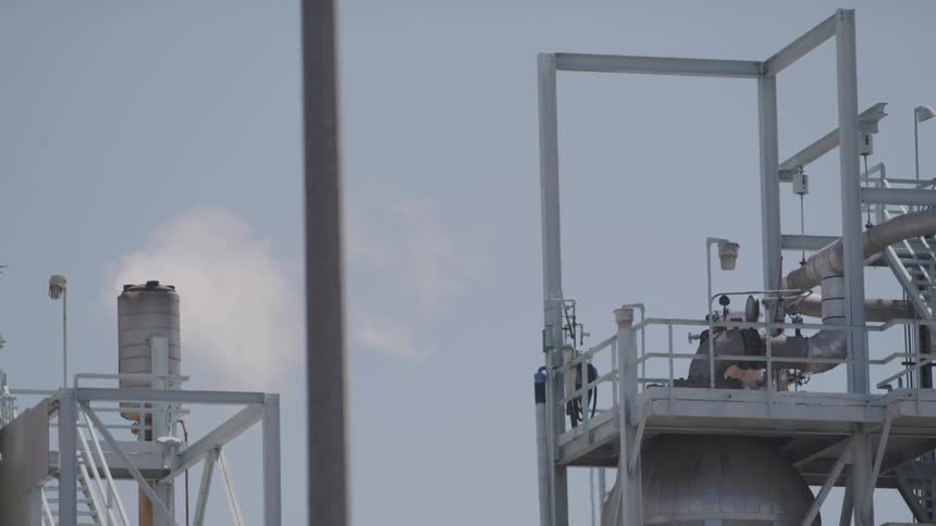 Smoke billows out of a smoke stack at a power plant