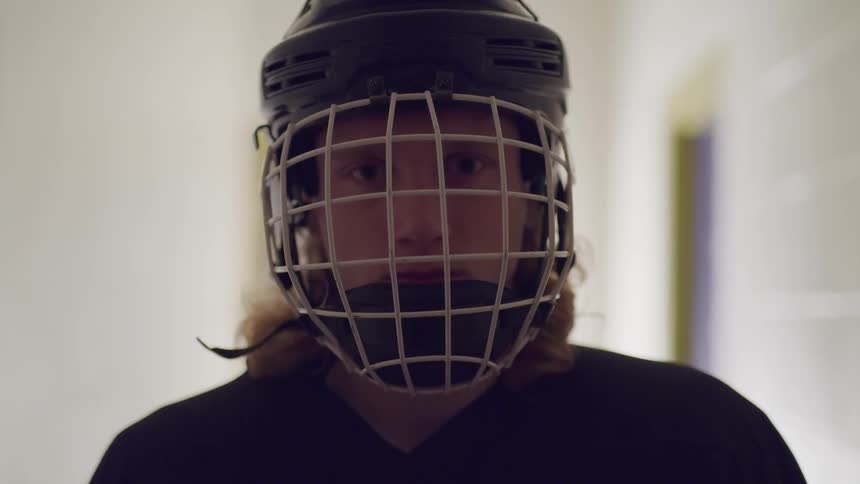 An athlete wearing a helmet with a face mask looks up