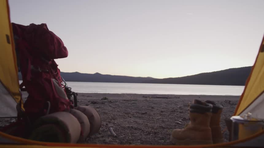 View of lake at sunrise from inside of tent