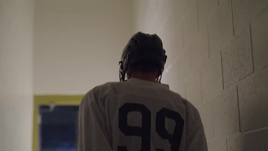 A hockey player walks down the tunnel towards the rink
