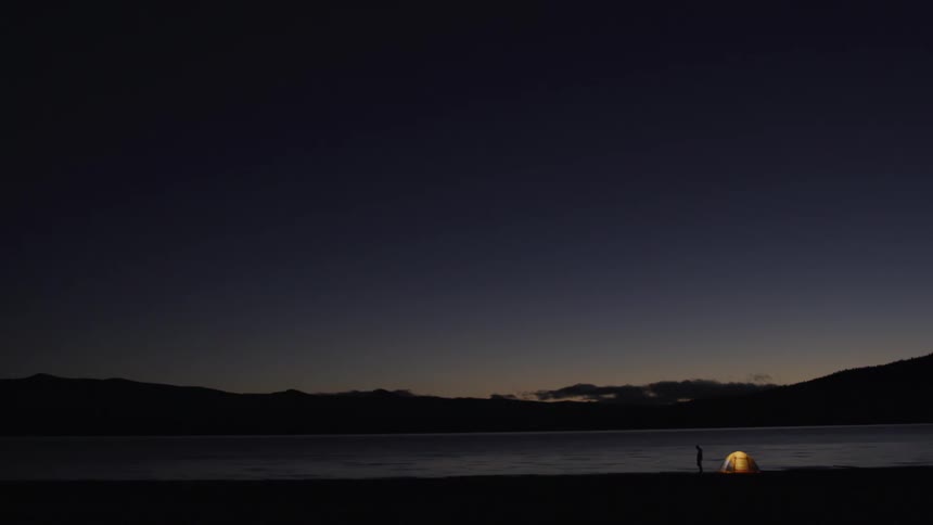 A person walks next to the tent