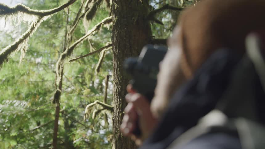 Male photographer shoots a video in the dense forest