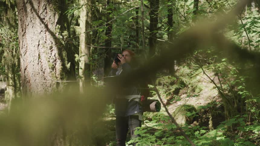 White man taking pictures of the nature in the middle of the forest