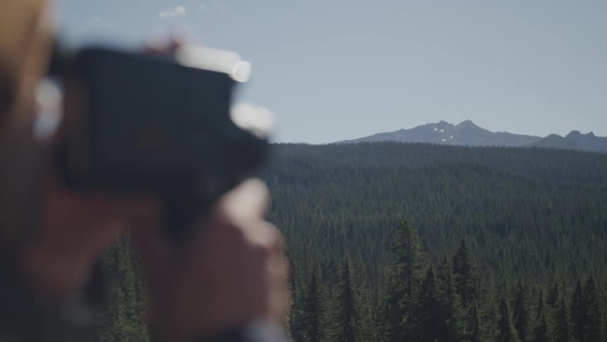 Person filming the landscape forest and mountains