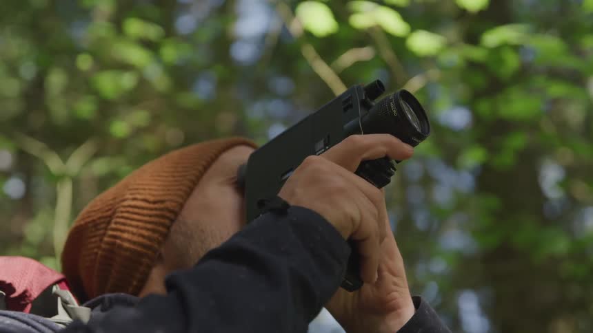 Male photographer shoots a video in the forest