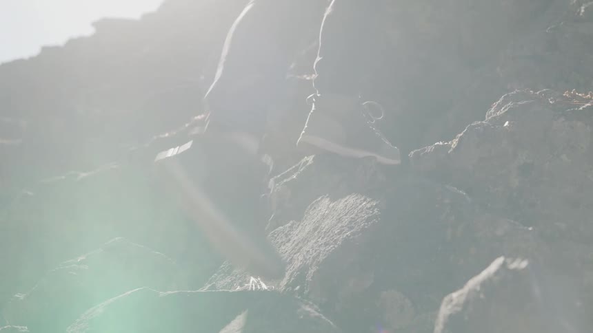 Man climbing rocks with social clothing