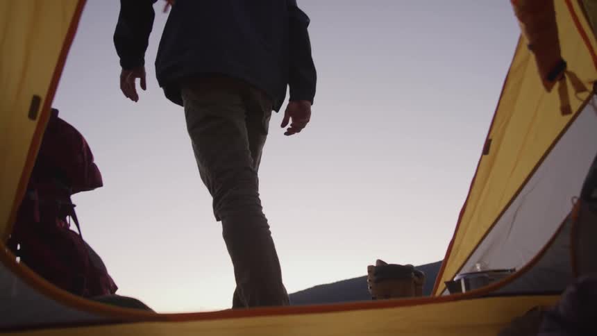 Man gets out of the tent at dusk