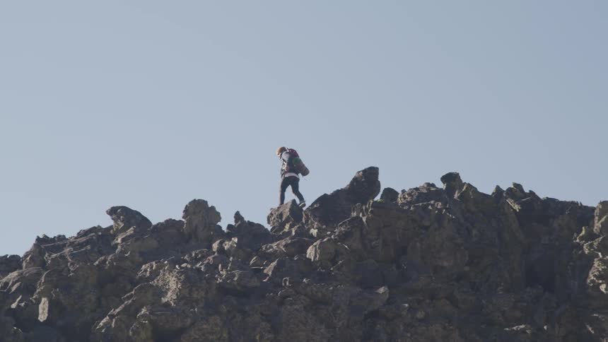 Hiker climbing a rocky mountain