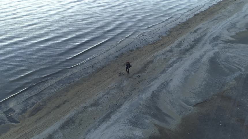 Hiker walking along the sea in a beach