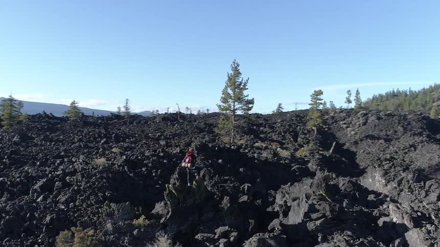Hiker stands on the rocks under a blue sky