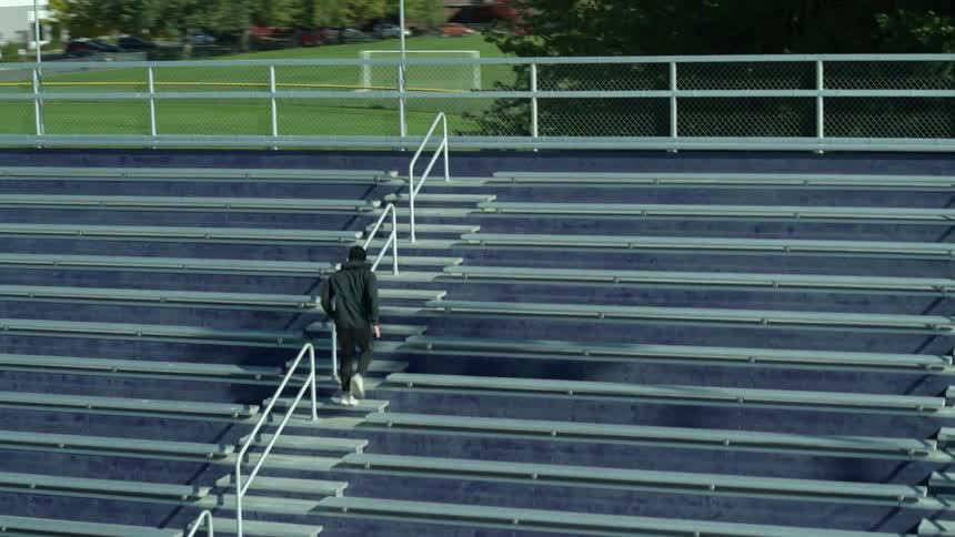 A man exercising running up bleachers