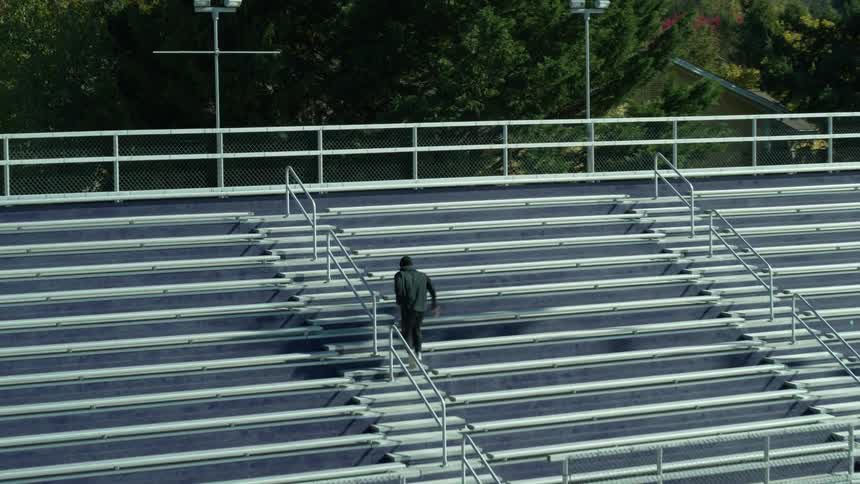 Man runs up the steps between the bleachers