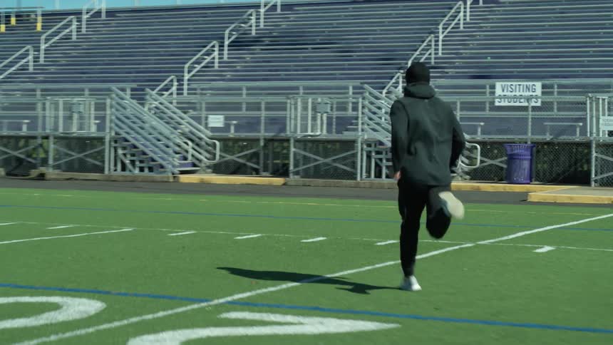A man is running across the football field