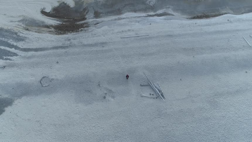 Aerial view of a man walking on the snow covered field